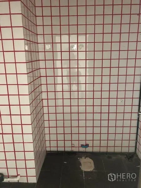 Retail Space for rent in Khlong Toei, Bangkok - Tiled utility wall with red grid and plumbing points, ideal for a pantry or wash area.