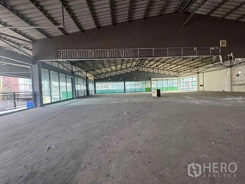 Warehouse for rent in Phra Khanong, Bangkok - Large upper hall with glass-lined walls and exposed trusses, ideal for sports, office or showroom.