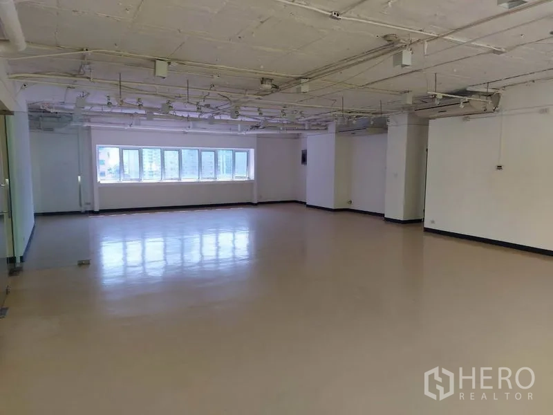 Office Space for rent in Pathum Wan, Bangkok - Open-plan office space with glossy flooring, exposed ceiling and a long window wall with city views.