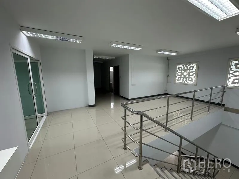 Warehouse for rent in Phra Nakhon Si Ayutthaya - Upper-level office landing with glass door, windows and metal handrail.
