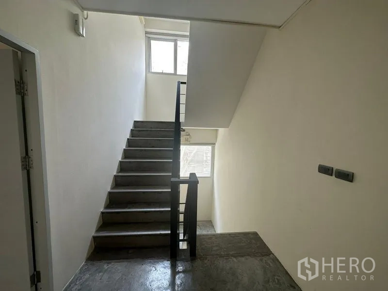 带办公室的家 出租在Wang Thonglang, Bangkok - 明亮楼梯间，混凝土台阶与黑色扶手。