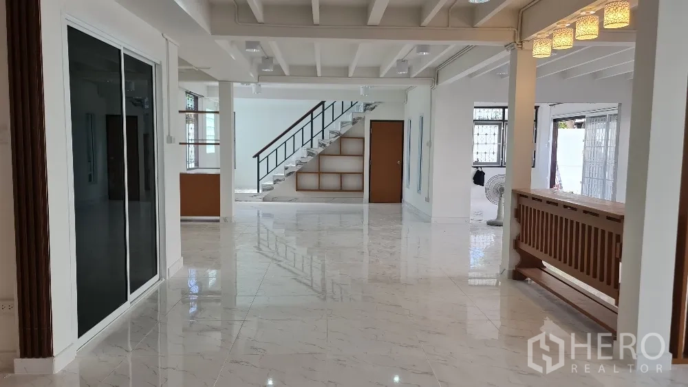 独栋房屋 for rent in Lat Phrao, Bangkok - 明亮客厅视角，推拉玻璃门与装饰吊灯清晰可见。