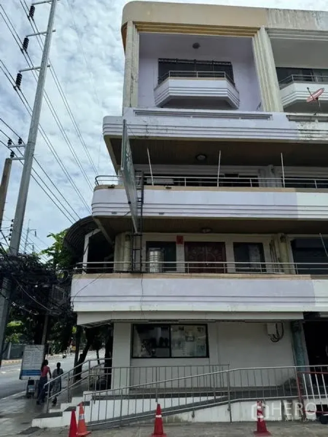 店屋 出租在Watthana, Bangkok - 建筑侧立面，多层阳台与门前坡道。
