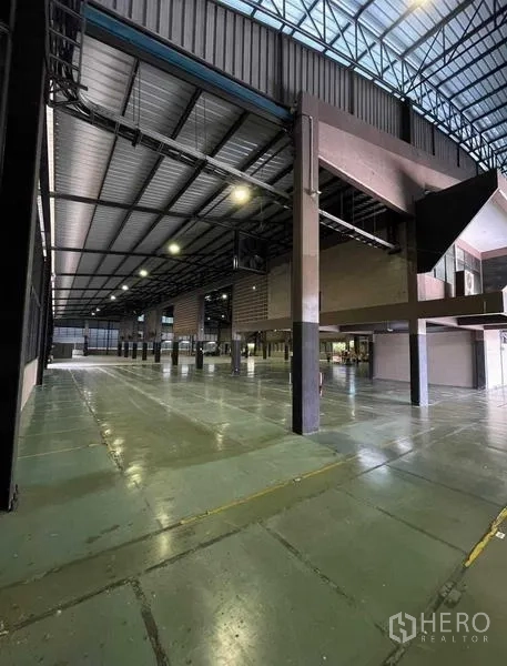 Warehouse for rent in Si Racha, Chon Buri - Spacious warehouse interior with high steel truss roof and polished epoxy floor.