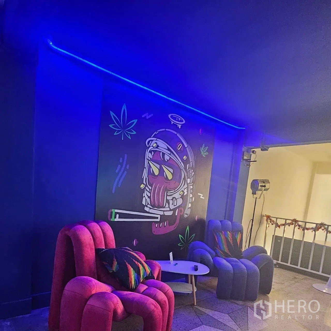 Shophouse for rent or sale in Khlong Toei, Bangkok - Lounge corner with blue LED lighting, colorful armchairs and a graffiti-style wall mural.