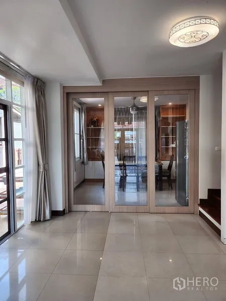 Detached House for rent in Bang Kapi, Bangkok - Open-plan area with sliding glass partition to the dining room and glossy tile floor.