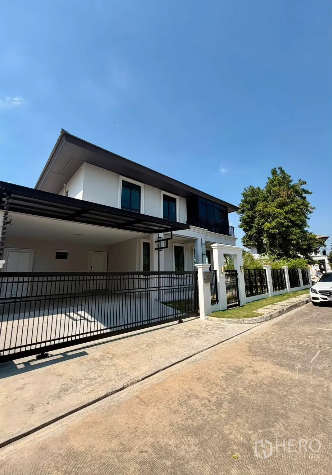 บ้านเดี่ยว for rent or sale in Prawet, Bangkok - ด้านหน้าบ้านสองชั้น โมเดิร์น มีกำแพงรั้วและที่จอดรถมีหลังคา