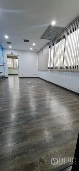 Office Space for rent in Watthana, Bangkok - Long room lined with windows, vertical blinds, and wood‑effect flooring.