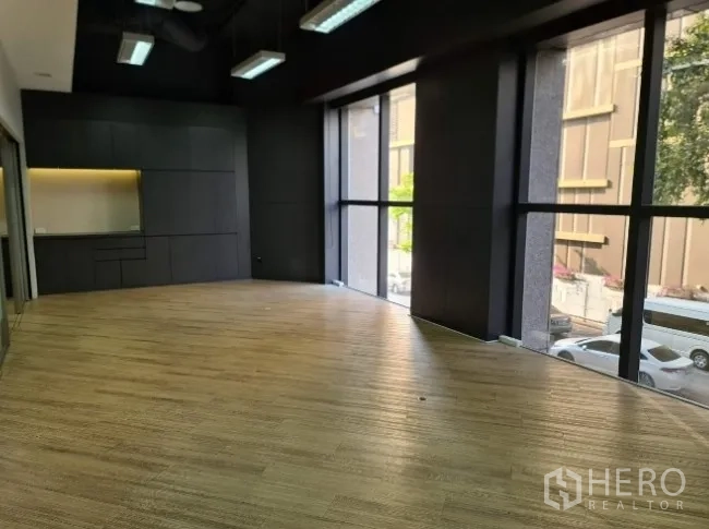 Office Space for rent - Bright workspace with floor-to-ceiling windows overlooking city buildings.