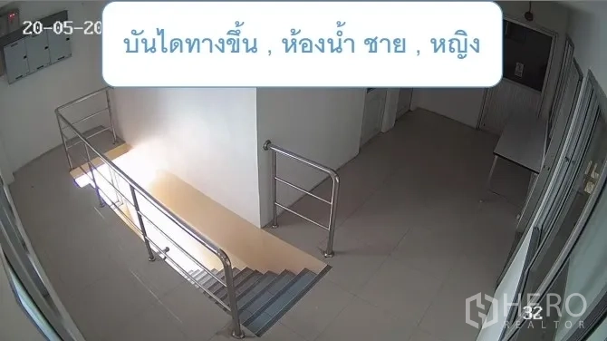 Warehouse for rent in Mueang Pathum Thani, Pathum Thani - Stairwell landing with stainless rails near restrooms off an office corridor.