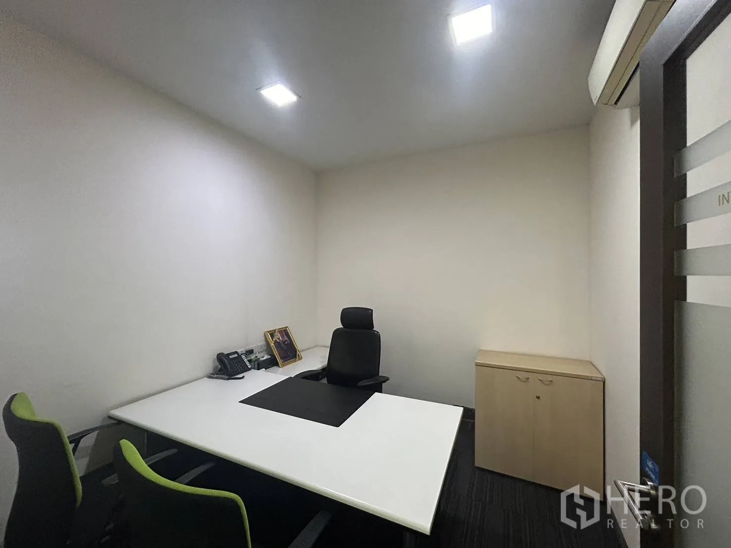 Office Space for rent - Compact executive office with desk, chairs, storage cabinet and air-conditioning unit.