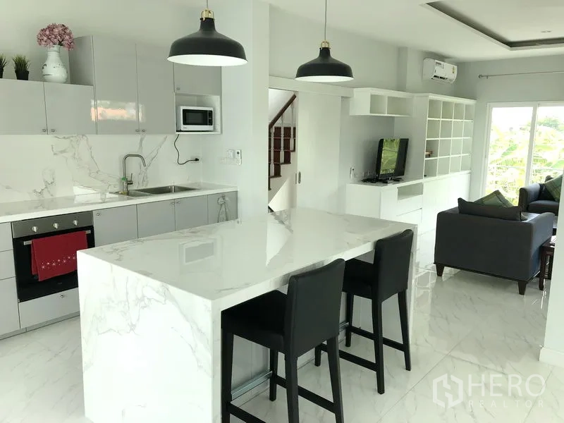 独立式住宅 出租或出售在Huai Khwang, Bangkok - 现代西式厨房，大理石中岛与吊灯，旁接休闲客厅