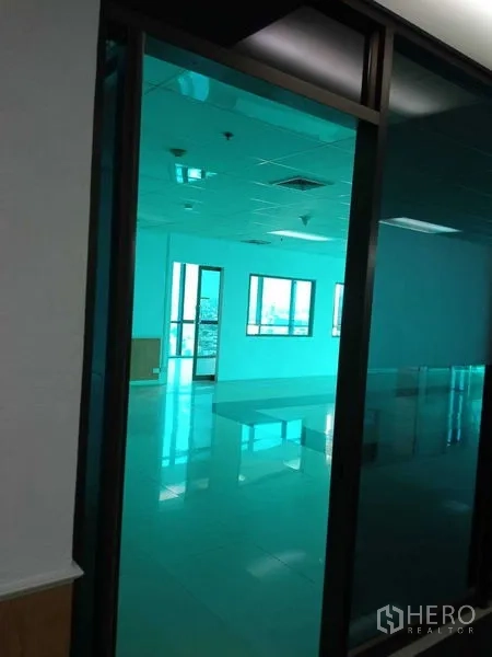 Office Space for rent in Huai Khwang, Bangkok - Glass-partition entrance opening to an open-plan office with tiled floors and drop ceiling.