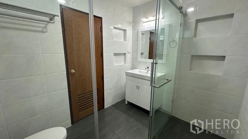 Detached House for rent in Watthana, Bangkok - Contemporary bathroom featuring white tiles and a glass shower.