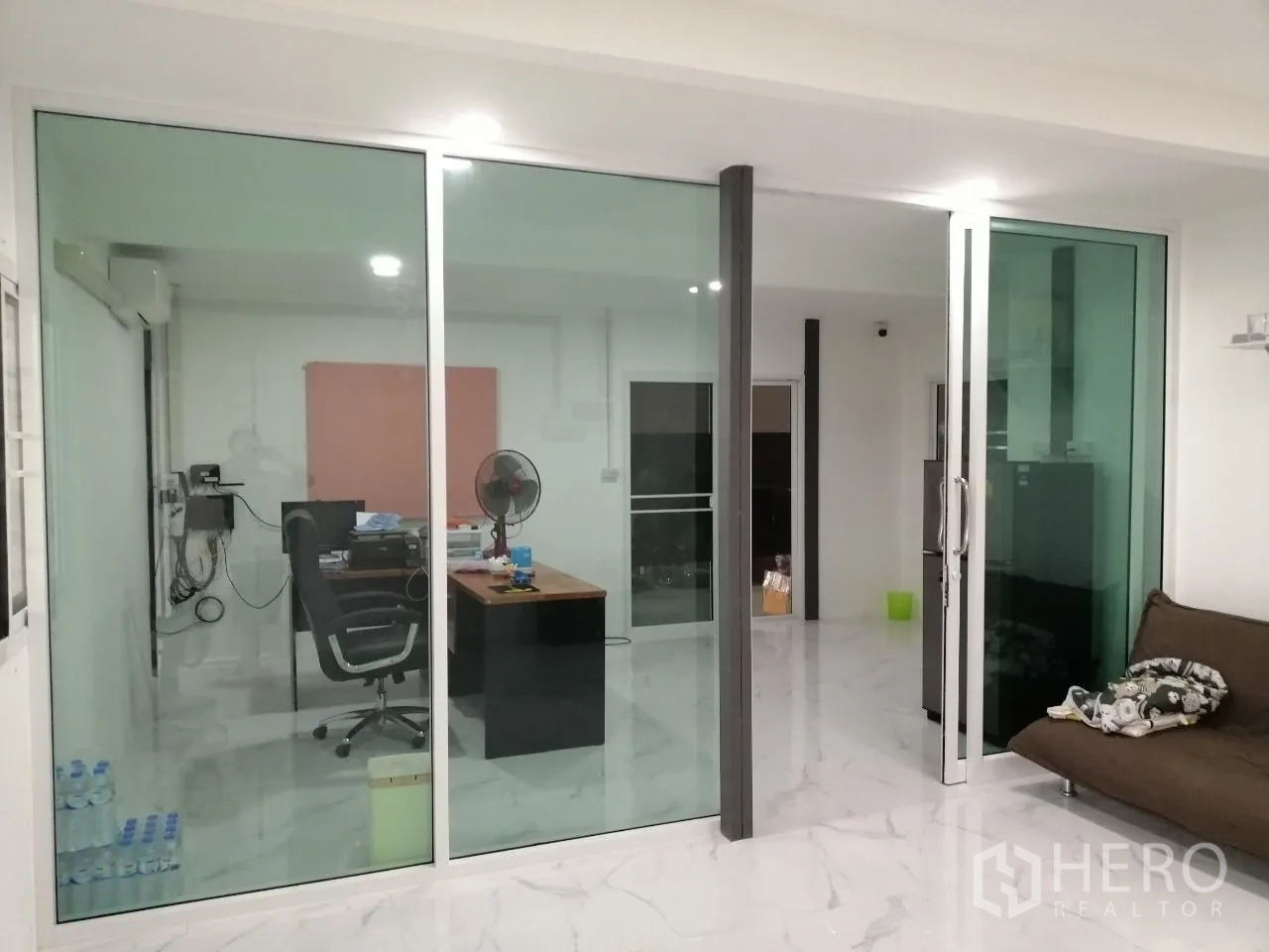 Warehouse for rent in Bang Bua Thong, Nonthaburi - Glass-partitioned office area with desk and marble-look flooring within the warehouse.