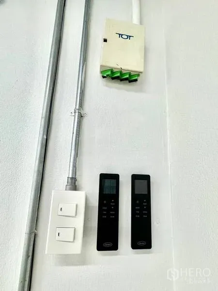 Office Space for rent in Khlong Toei, Bangkok - Wall controls with dual AC remotes and a fiber internet box