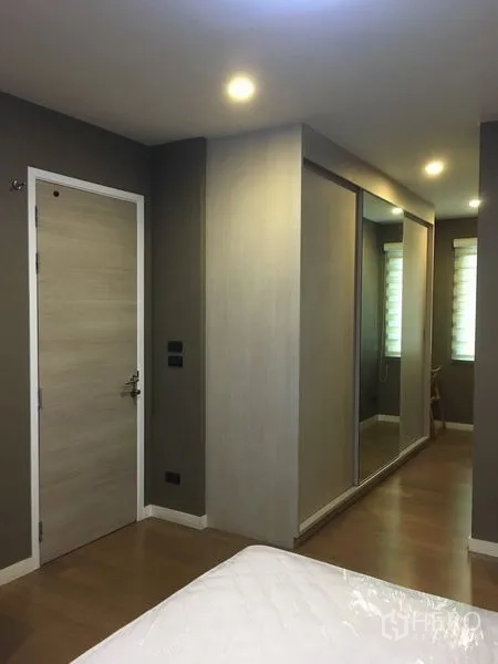 Detached House for rent or sale in Bang Kapi, Bangkok - Bedroom corridor with mirrored wardrobe and recessed lighting.