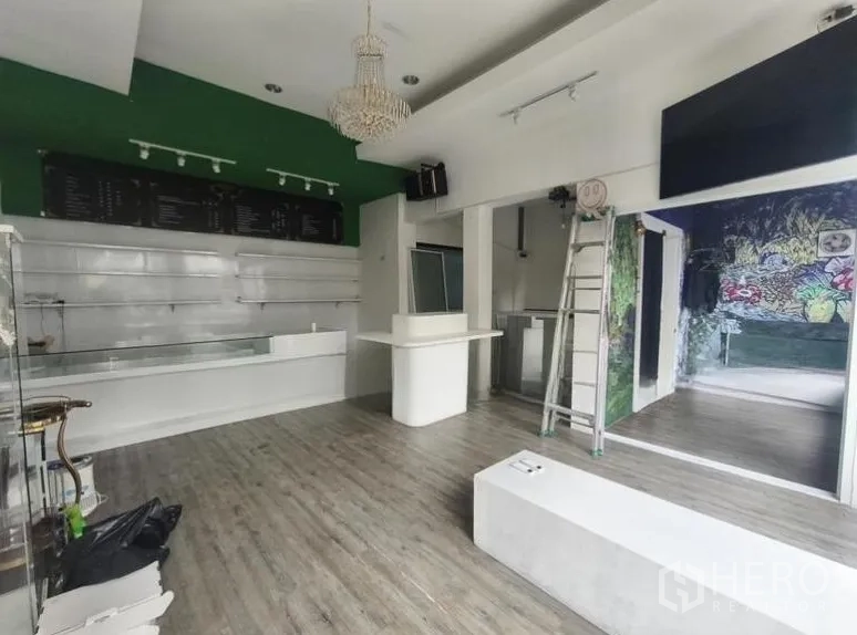 零售空间 for rent in Watthana, Bangkok - 开间零售室内，服务台、木纹地板与吊灯，特色墙面，近通罗BTS