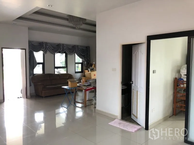 Detached House for sale in Lam Luk Ka, Pathum Thani - Sitting area with sofa, windows and a doorway to a bathroom.