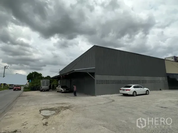 Warehouse for rent in Thanyaburi, Pathum Thani - Covered loading bay at the warehouse front with a large parking apron beside the main road.