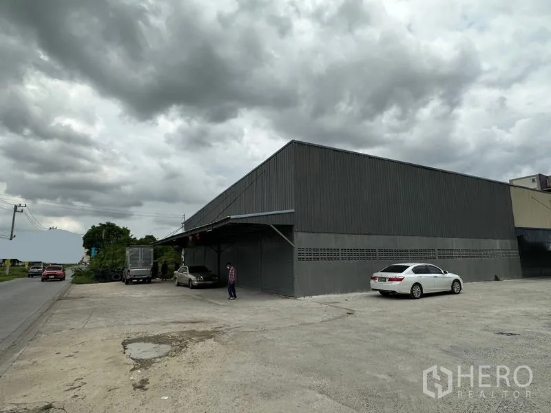 Warehouse for rent in Thanyaburi, Pathum Thani - Covered loading bay at the warehouse front with a large parking apron beside the main road.