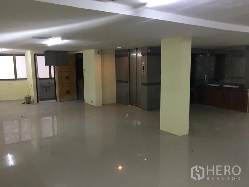 Home Office for rent in Watthana, Bangkok - Office area showing twin elevators, a sink corner and wide tiled flooring.