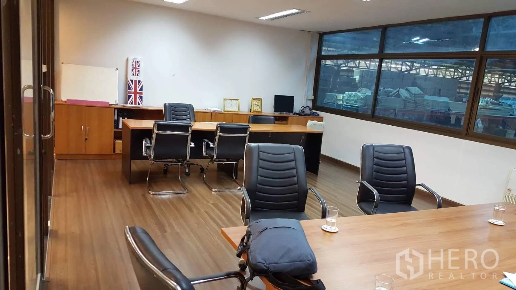 Factory for rent or sale in Pathum Thani - Meeting room and office with wood floors, desks and executive chairs.