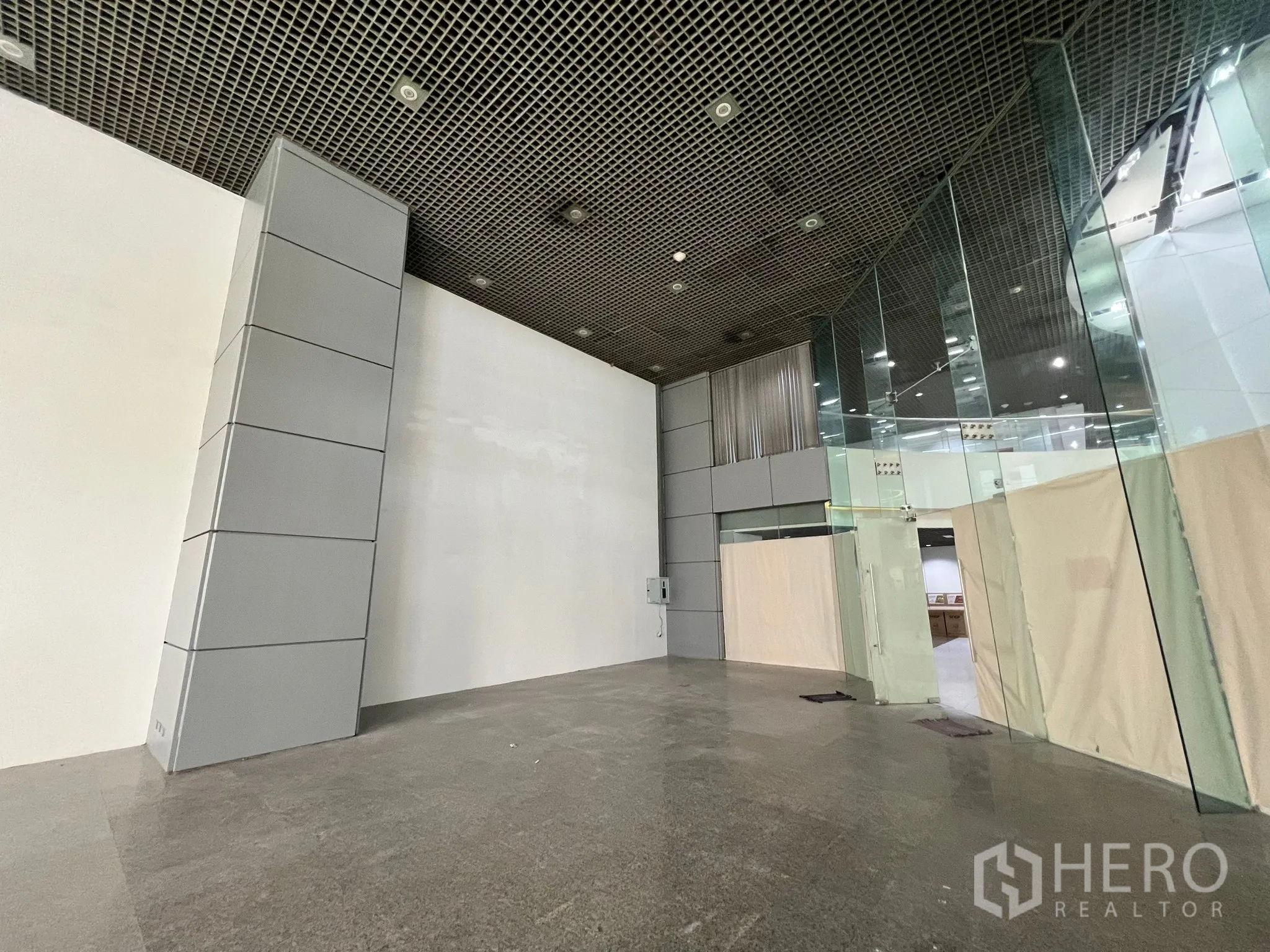 Retail Space for rent in Watthana, Bangkok - Shell retail interior with high ceiling, polished stone floors, and full-height glass partitions ready for fit-out.