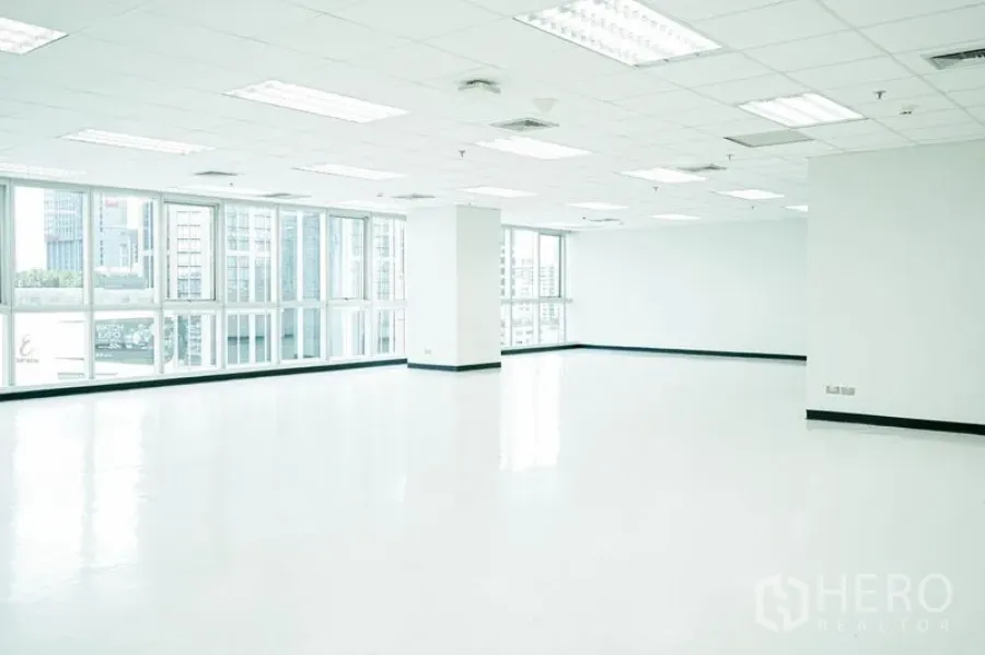 Office Space for rent in Watthana, Bangkok - Bright empty floor plate with fluorescent lighting and corner glazing.