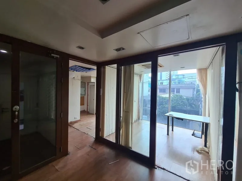 Office Space for rent in Bang Rak, Bangkok - Bright glass meeting room with city views and a work table.