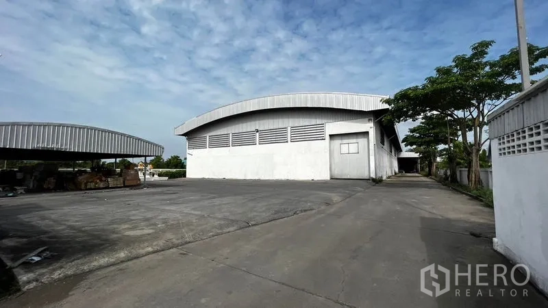Factory for rent or sale in Pathum Thani - Front elevation of the factory with ample truck turning space and canopy.