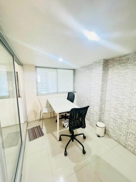 Shophouse for rent in Phra Khanong, Bangkok - Compact meeting room with sliding glass door, wallpapered feature wall and tiled floor.