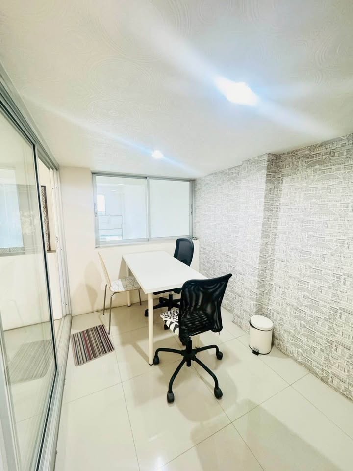 Shophouse for rent in Phra Khanong, Bangkok - Compact meeting room with sliding glass door, wallpapered feature wall and tiled floor.