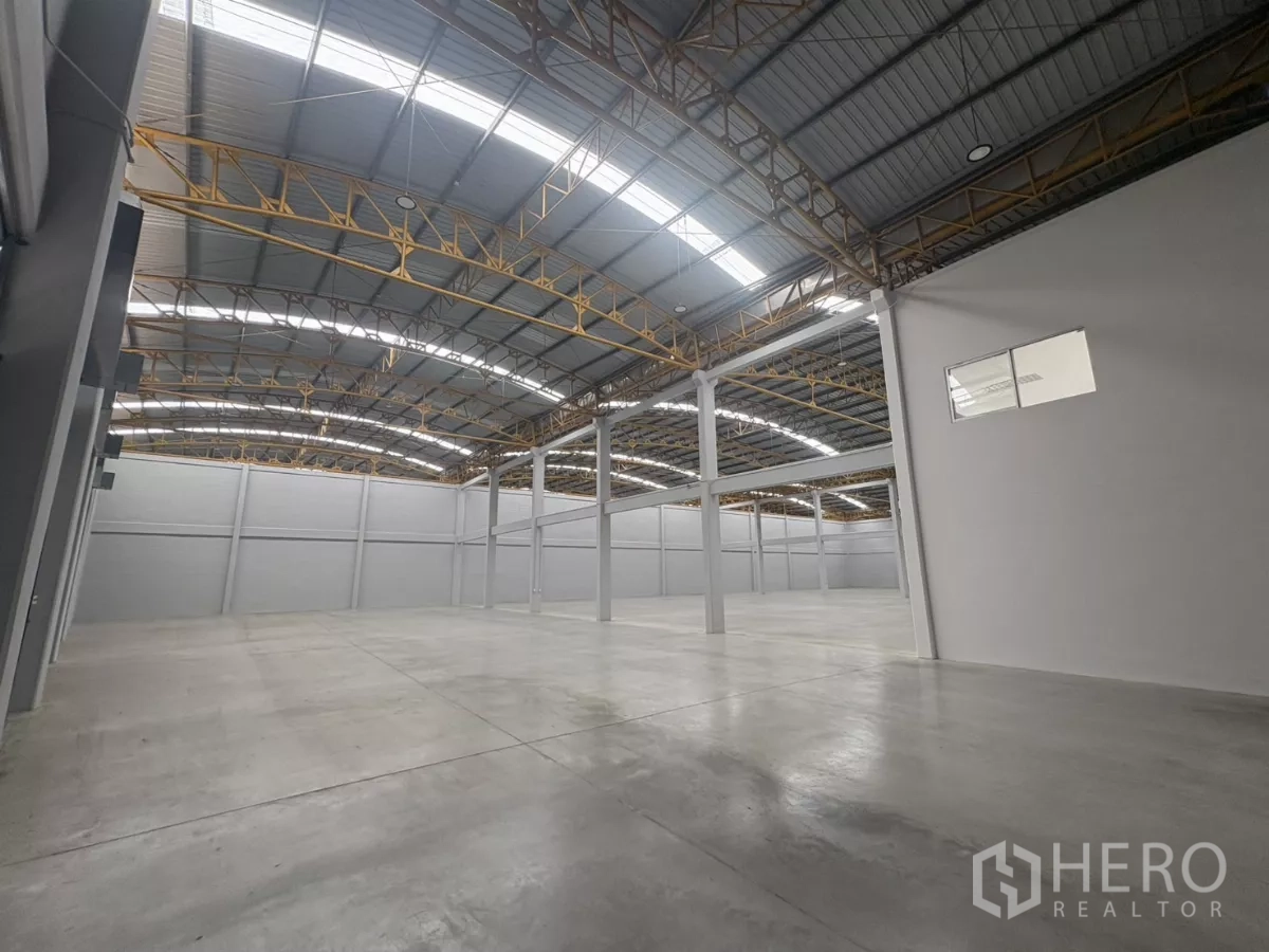 Factory for rent in Bang Phli, Samut Prakan - Vast warehouse hall with polished concrete floor and high arched steel roof.