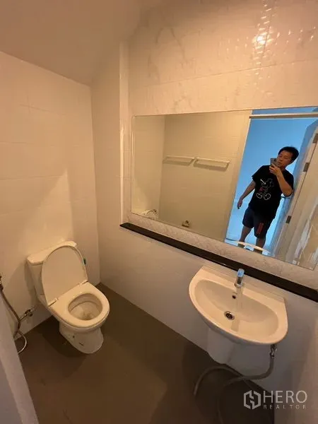 Home Office for rent or sale - Guest bathroom with toilet, pedestal sink and large wall mirror.
