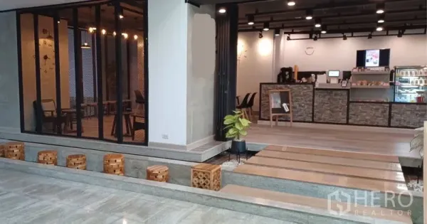 Retail Space for rent in Khlong Toei, Bangkok - Open-plan café-style retail unit with service counter, step walkway, indoor plants, and black track lighting.