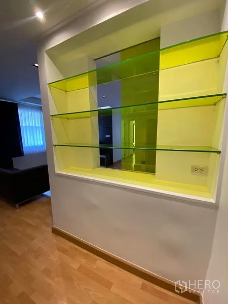 Condominium for rent in Khlong Toei, Bangkok - Built-in display niche with glass shelving and yellow accent panel.