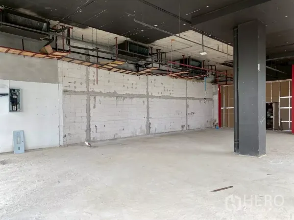 Retail Space for rent - Open-plan unit with exposed ceiling services, white block wall and concrete floor.