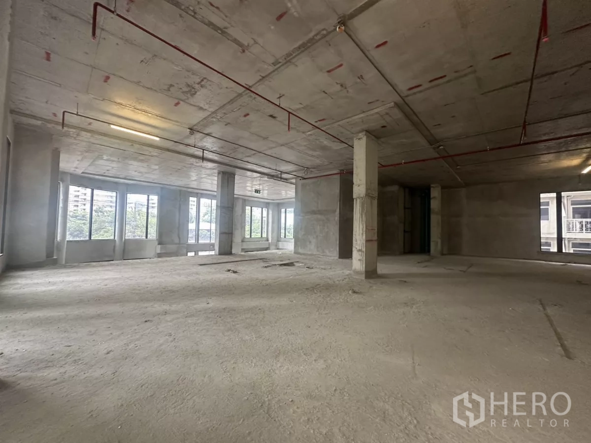 Retail Space for rent in Watthana, Bangkok - Bright corner area with expansive glazing and greenery views in an empty retail shell.