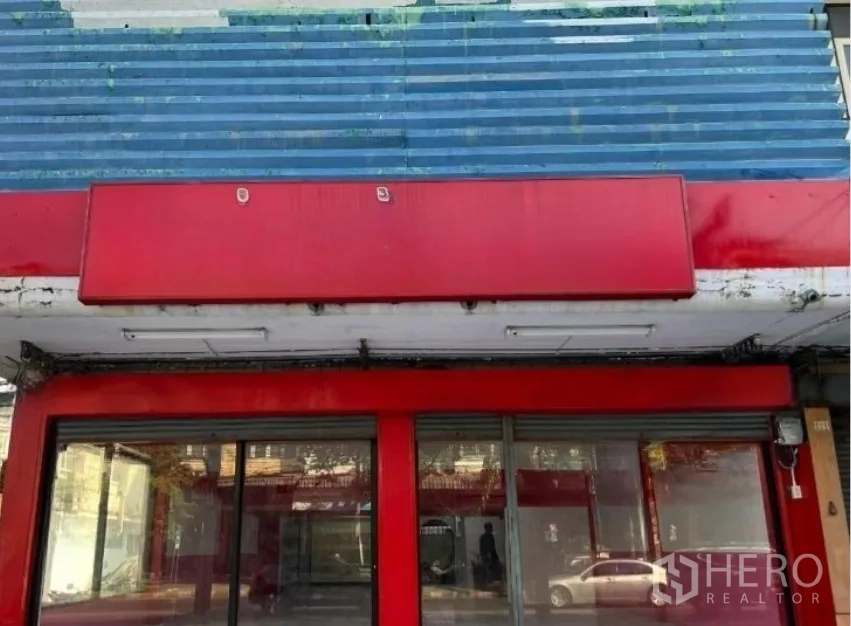 Shophouse for rent in Suan Luang, Bangkok - Close-up of red awning and sliding glass doors at the shop entrance.