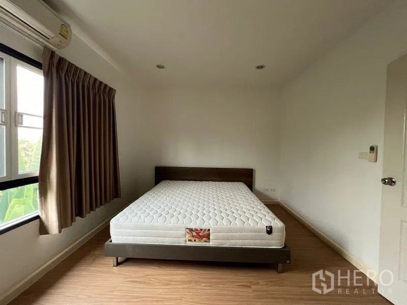 联排别墅 出租在Bang Kapi, Bangkok - 次卧配大窗、棕色窗帘和双人床。
