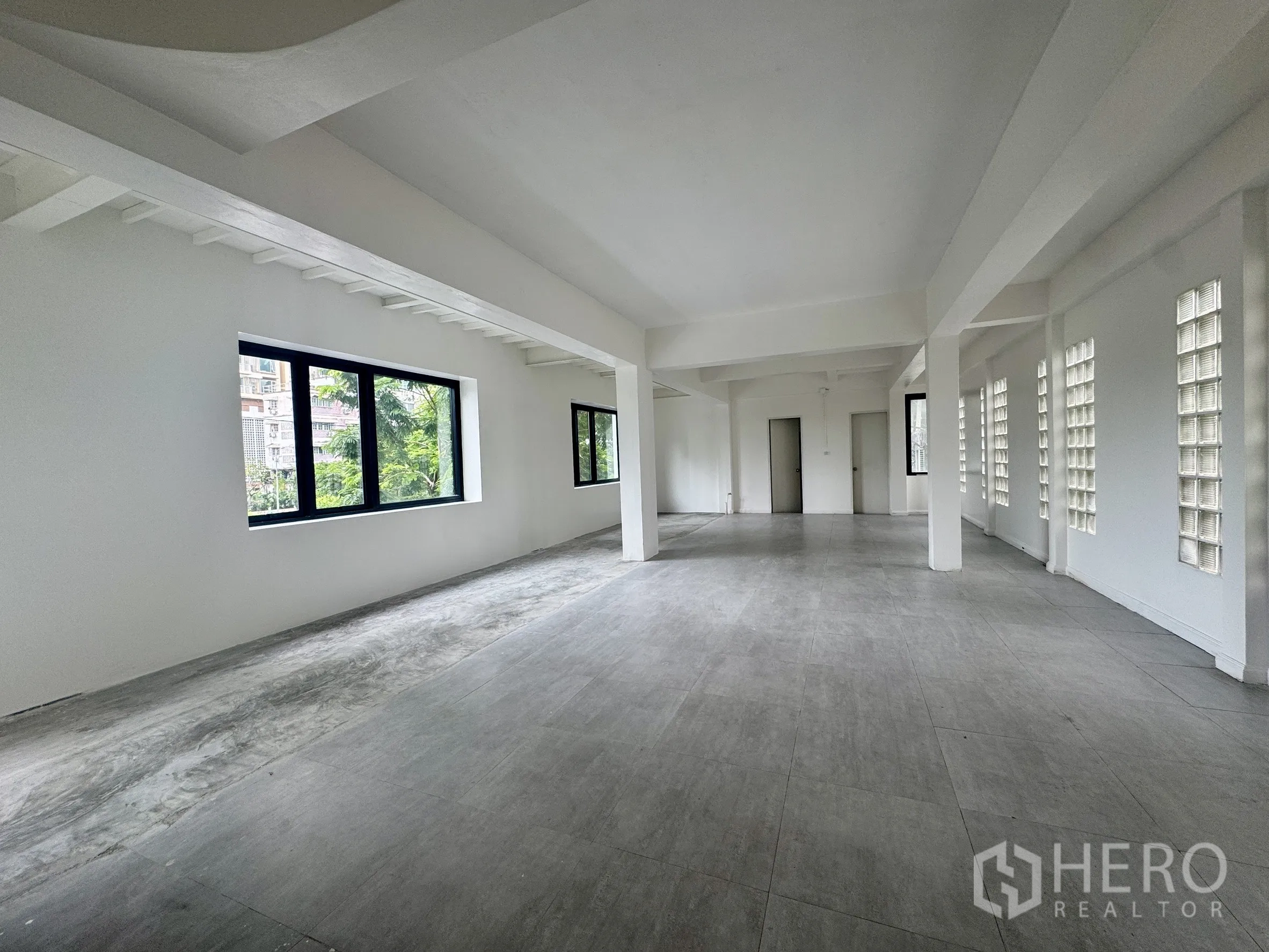 Office Space for rent in Sathon, Bangkok - Long open workspace with glass block wall, windows and two internal doors.