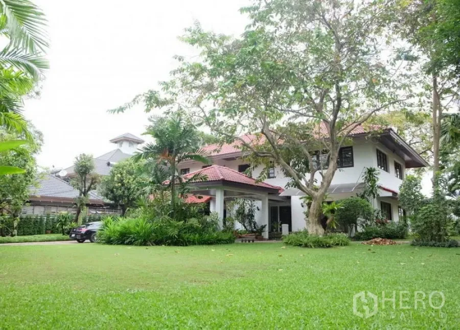 Detached House for rent in Bang Phli, Samut Prakan - Two-storey detached house with red tiled roof set on a large lawn with mature trees in a gated estate.
