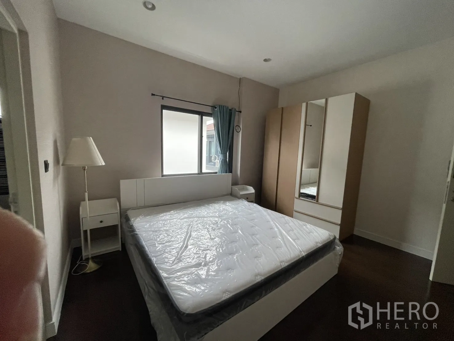 Detached House for rent in Bang Kapi, Bangkok - Bedroom with bed, lamp and wardrobe near ensuite door.