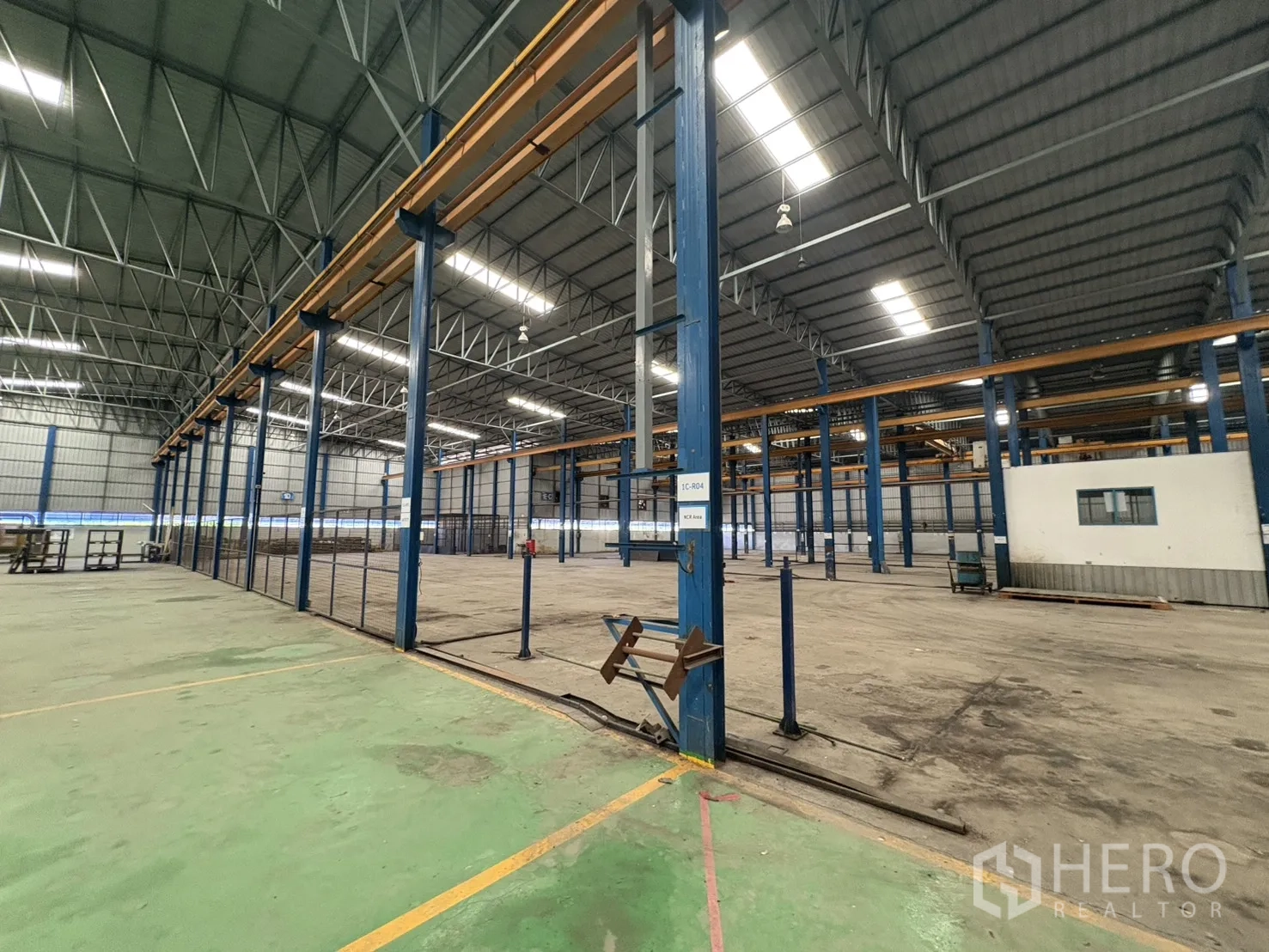 Factory for rent in Phra Pradaeng, Samut Prakan - Clear warehouse zone with fenced sections and tall ceiling.