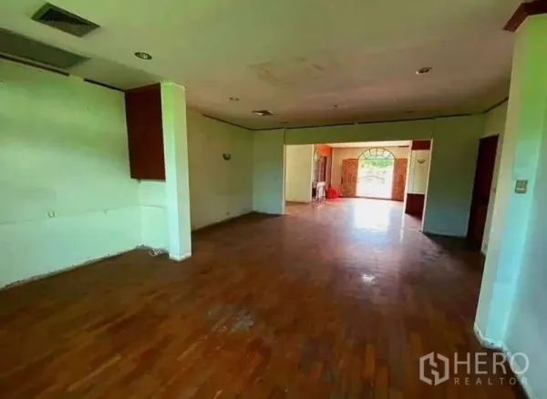 Detached House for sale in Prawet, Bangkok - Spacious living area with wooden flooring and large windows inside the house.