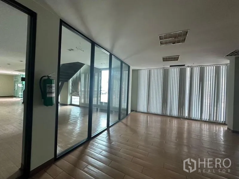 Warehouse for rent in Prawet, Bangkok - Ground-floor lobby with a glass-partition meeting room beside the staircase.