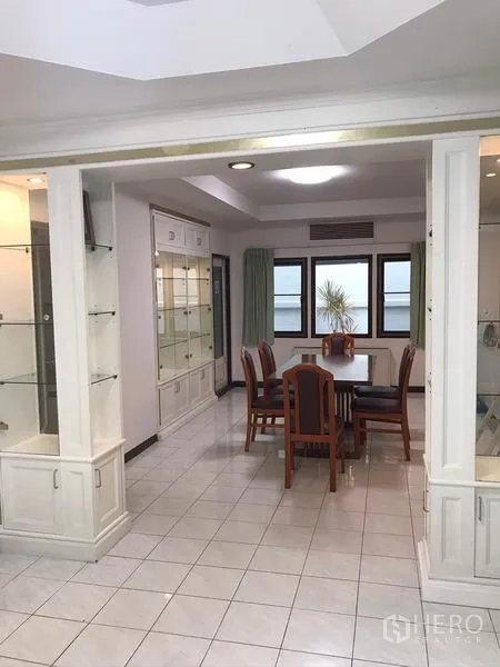 独立式住宅 出租在Phra Khanong, Bangkok - 开放式视角通往餐区，白色柜体与亮面地砖。