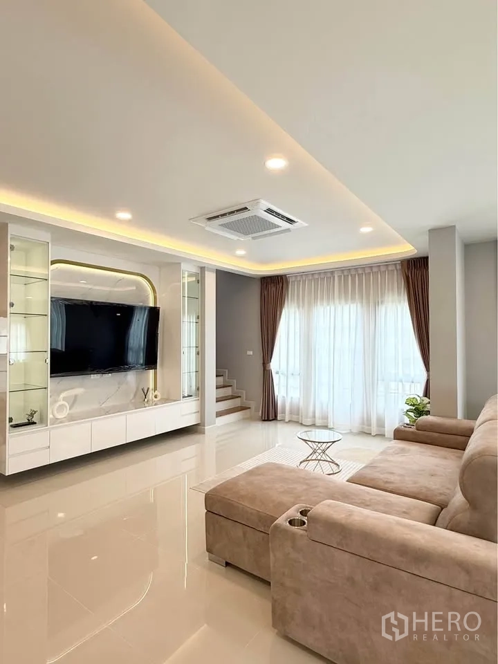 บ้านเดี่ยว for rent in Bang Phli, Samut Prakan - ห้องนั่งเล่นชั้นล่าง ผนังทีวีบิลท์อินและโซฟาเข้ามุม.