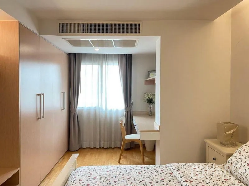 Condominium for sale in Phra Khanong, Bangkok - Bright bedroom with built-in wardrobes, window curtains, and a compact study nook.